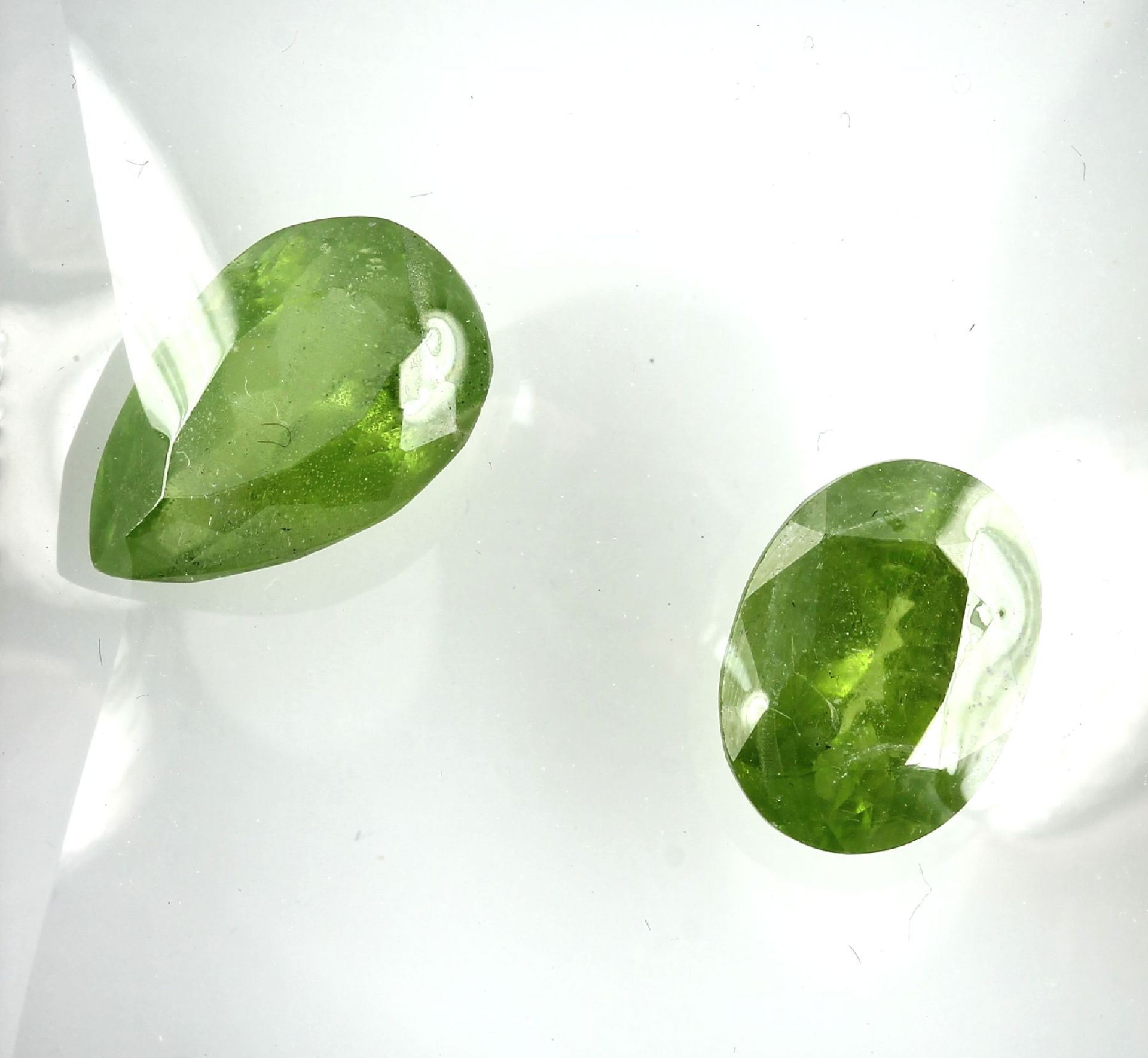 Lot 2 lose Peridots, zus. ca. 22.8 ct, 1 x ovalfacett.