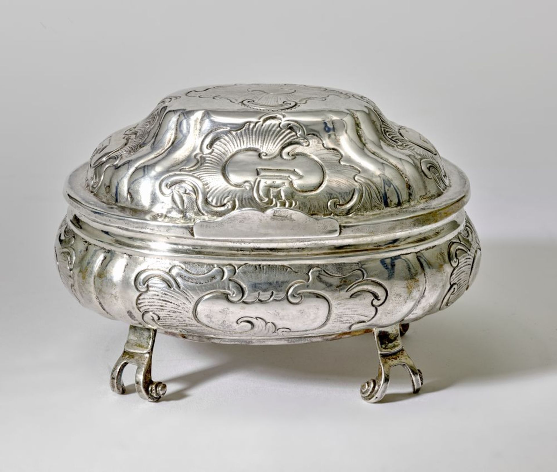SILVER OVAL CAVIAR WITH A LID ON ROUNDED LEGS WITH A ROCAILLE DECOR.
