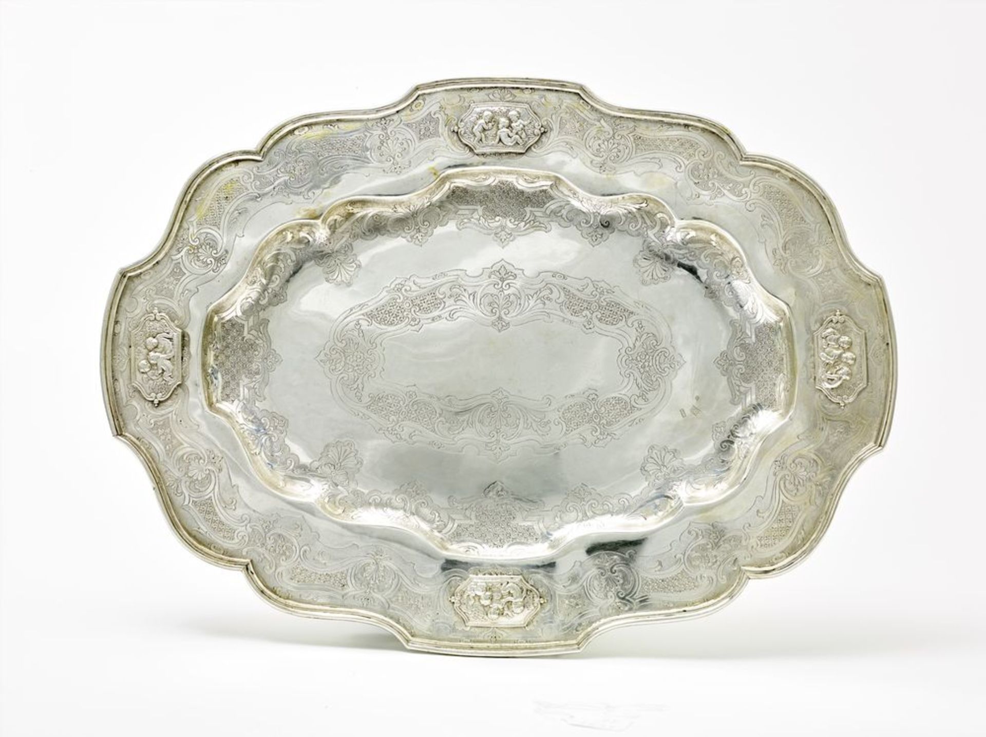 Silver oval dish decorated with four cartouches with the image of playing Putti. [...]