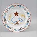 SOVIET PROPAGANDA PLATE WITH THE IMAGE OF A RED STAR, HAMMER, AND SICKLE, Designed by [...]