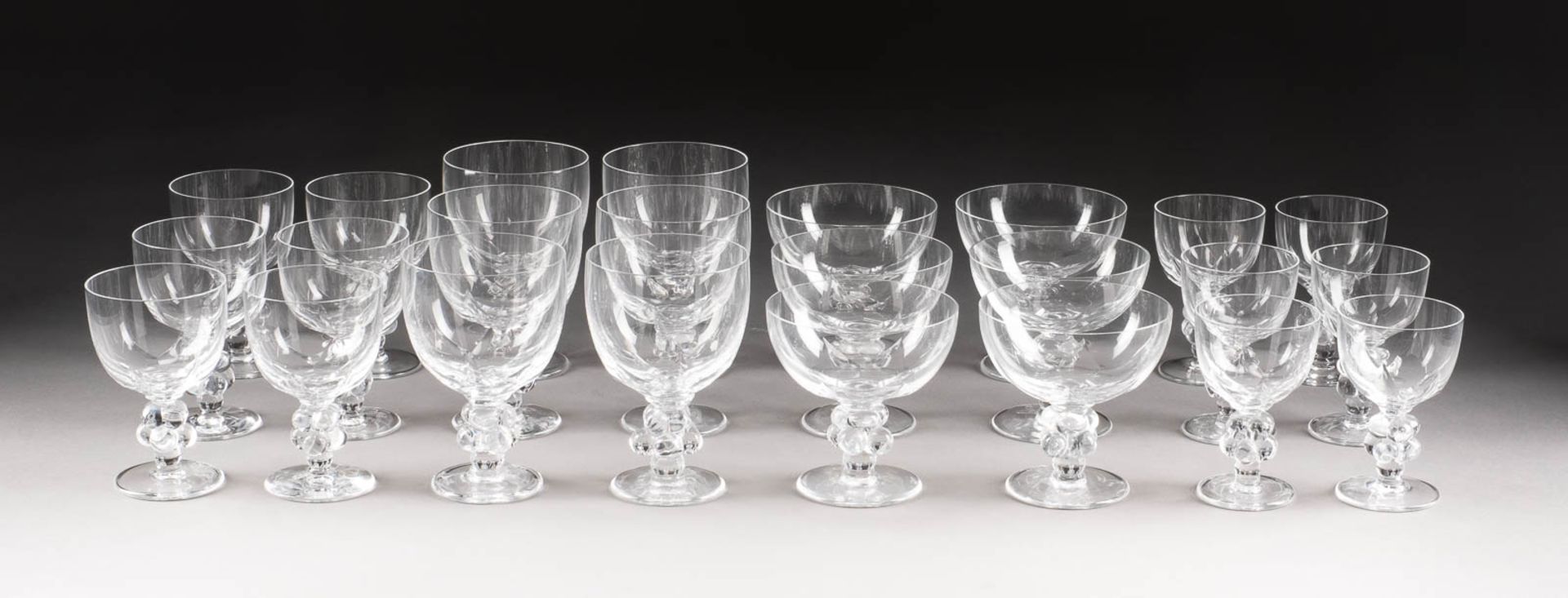 24 TAFELGLÄSER Frankreich, Paris, Lalique, 2. Hälfte 20. Jh. Farbloses Kristallglas. H. 12-15 cm.