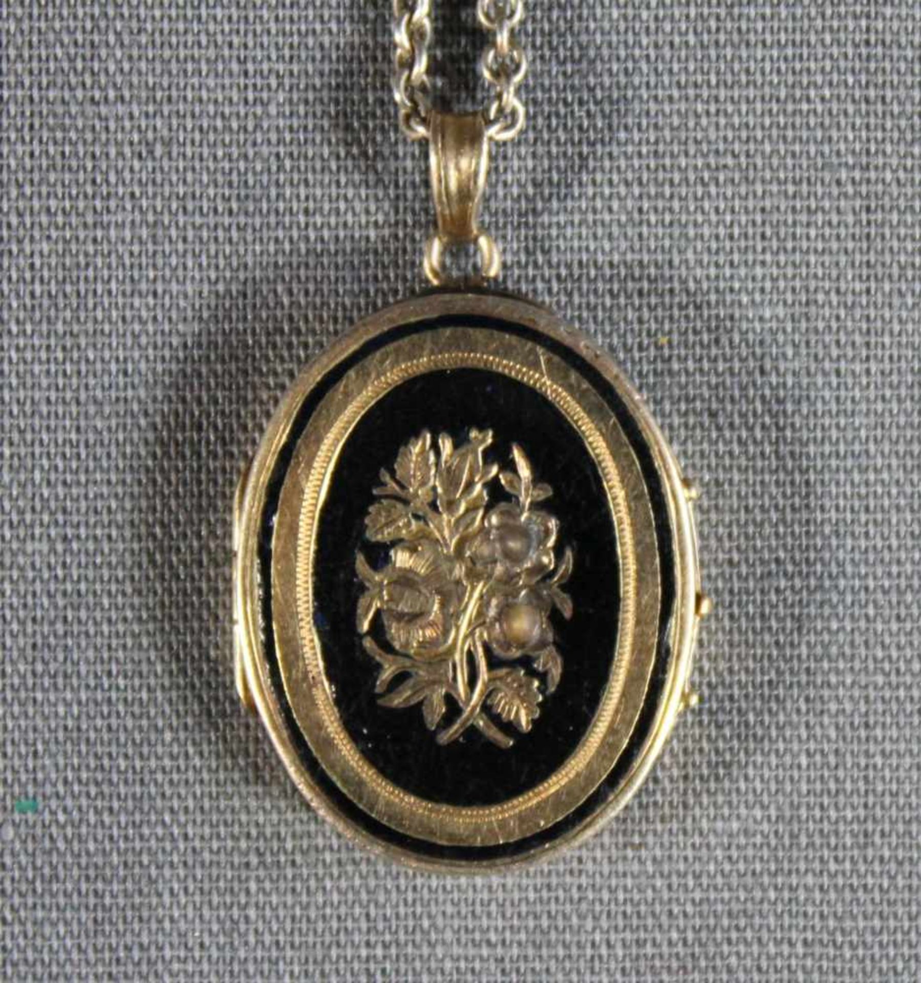 1 kleines ovales Medaillon vergoldet, schauseitig mit floraler Gravur und partiell schwarz