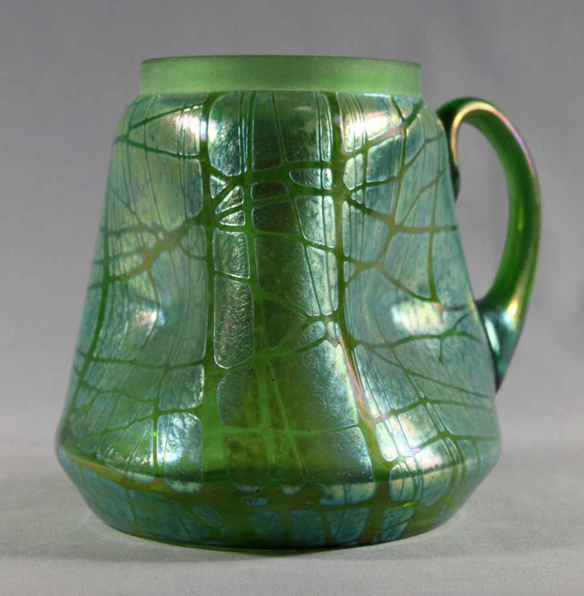 1 großer Henkelkrug grünes Glas, Jugendstil "Lötz", Wandung 3-fach gedellt, mit aufgearbeitetem