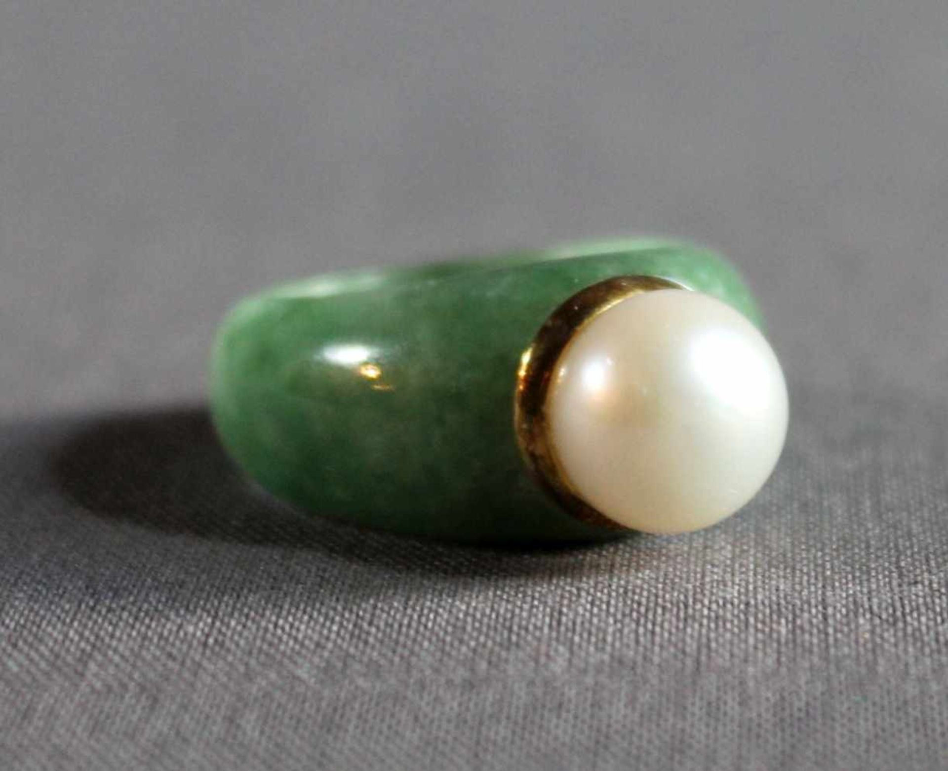 1 Ring, breiter Jade-Reif/Silber (925/000), Ringkopf besetzt mit großer weißer Perle im schönen