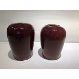 A PAIR OF SANG DE BOEUF GLAZED JARS AND COVERS