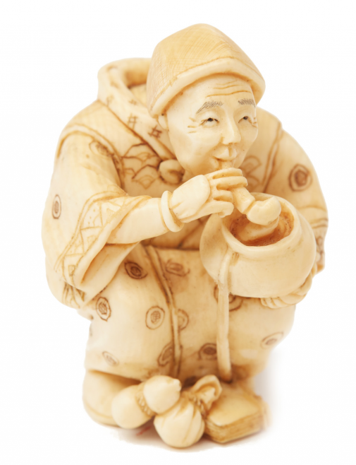 AN IVORY FIGURINE OF A MAN SMOKING A PIPE