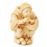 AN IVORY FIGURINE OF A MAN SMOKING A PIPE