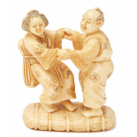 AN IVORY FIGURINE OF A DANCING COUPLE