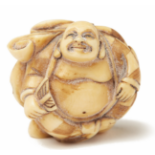 AN IVORY NETSUKE FIGURINE OF A PAIR OF MEN JOINED BACK TO BACK