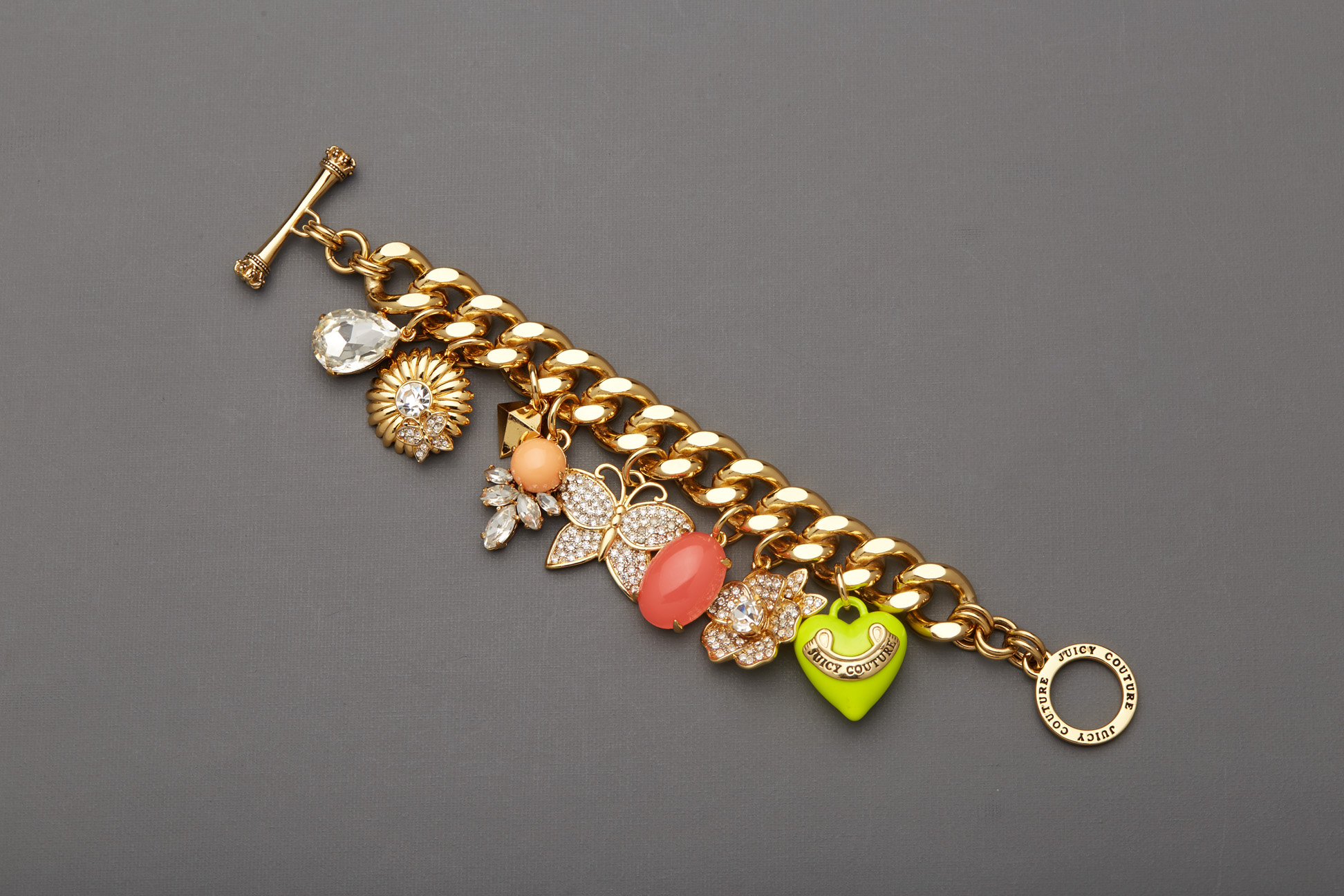 A JUICY COUTURE GOLD TONE CHARM BRACELET