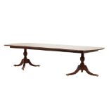 A GEORGE III STYLE TWIN PILLAR EXTENDING DINING TABLE