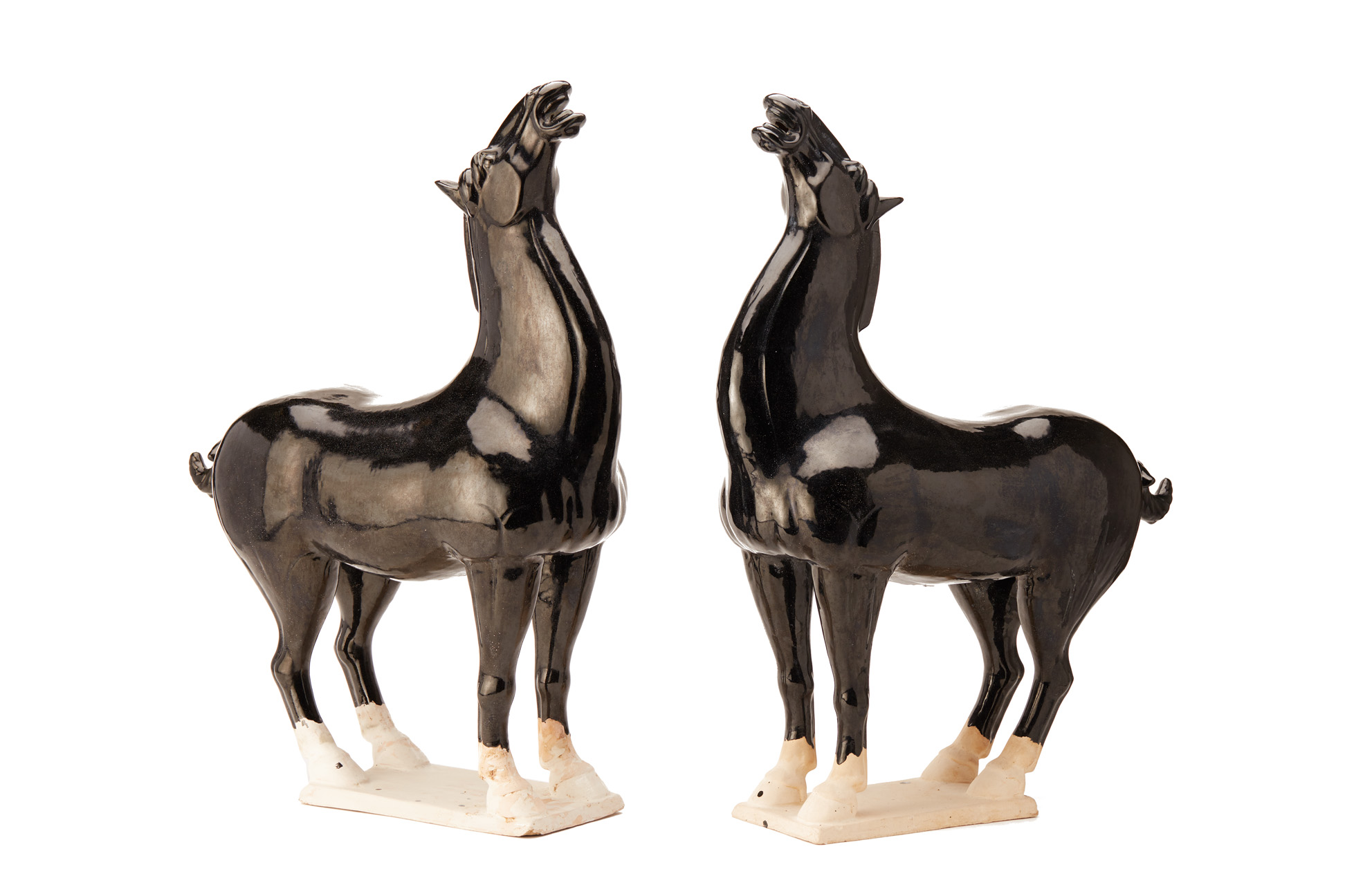 A PAIR OF CHINESE TANG STYLE BLACK GLAZED MODELS OF HORSES