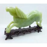 A Chinese carved jade figure of a horse, 18.5cm, on a wooden stand