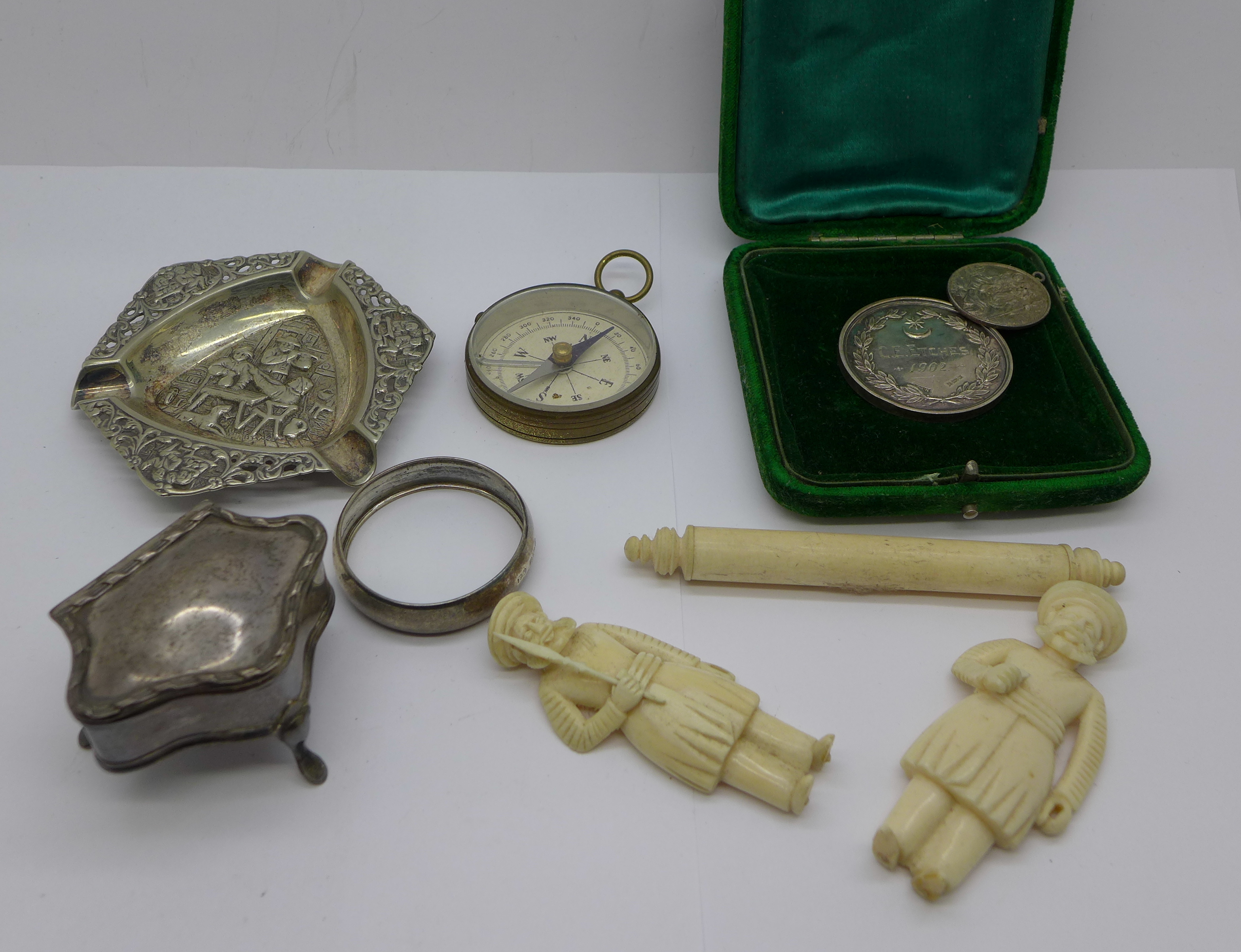 A small hallmarked silver trinket box, a white metal ashtray, silver napkin ring, ivory figures, a