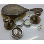 A silver backed brush, a pair of small silver candlesticks, a silver fob, a silver napkin ring, etc.