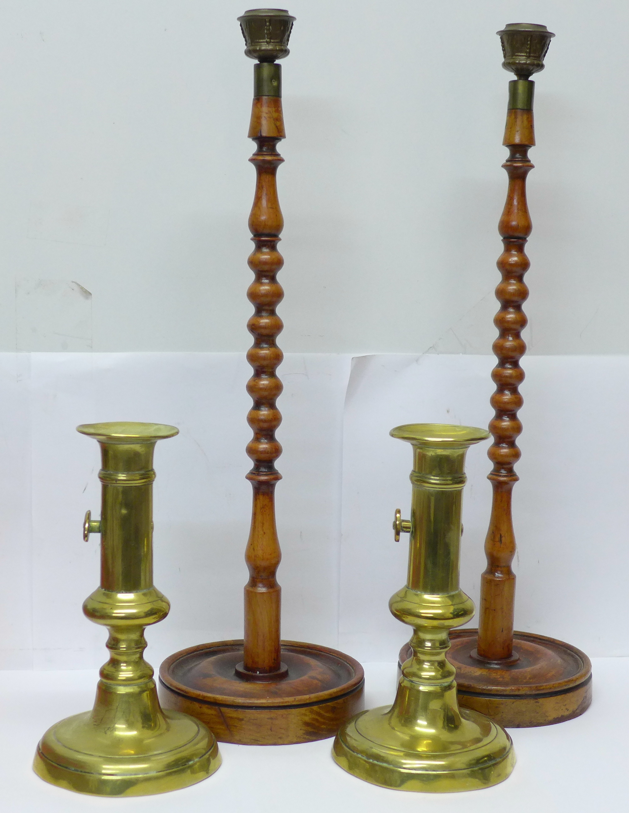 A pair of 19th Century brass candlesticks and a pair of tall bobbin turned candlesticks