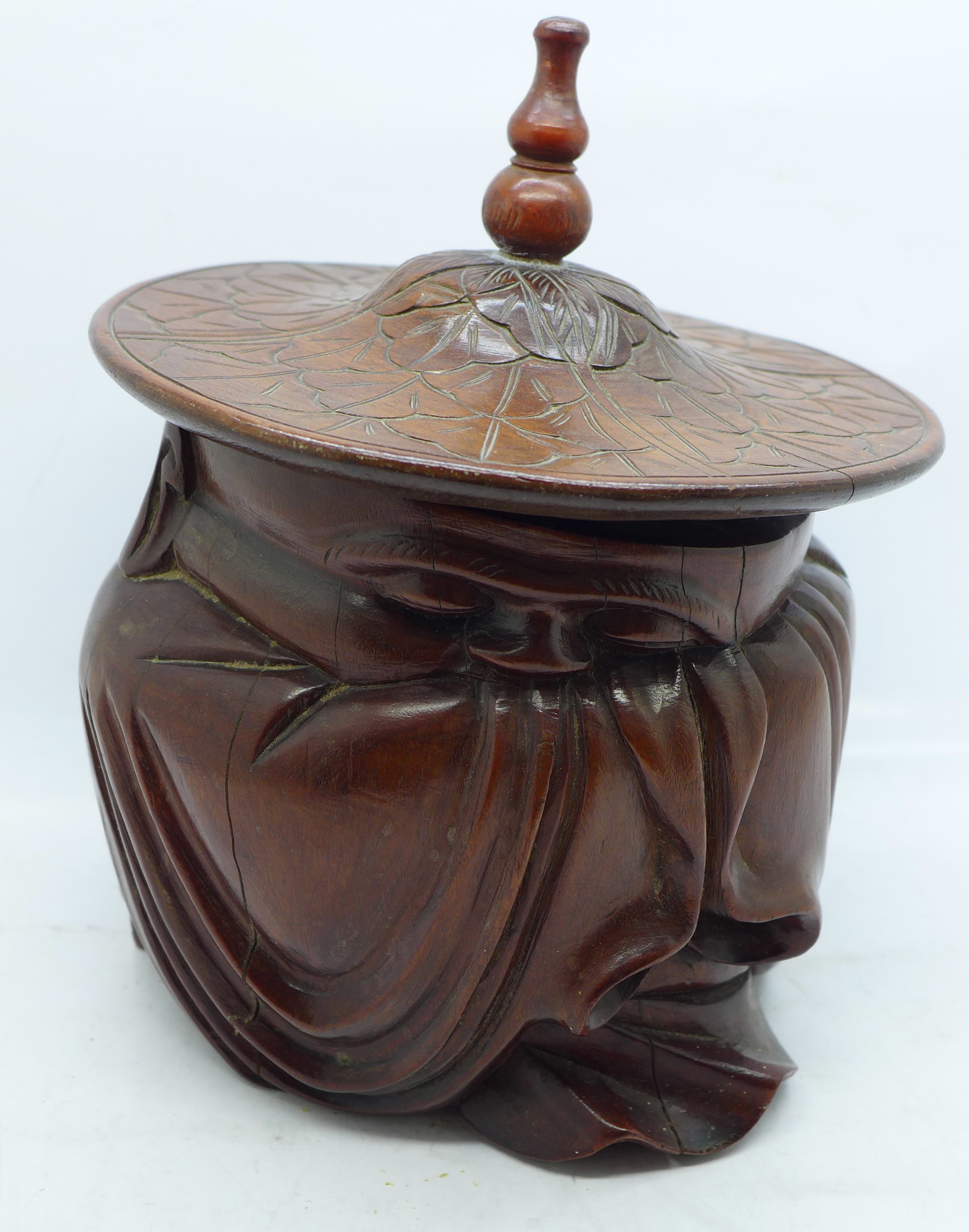 A carved Chinese lidded pot in the form of a sleeping seated elder