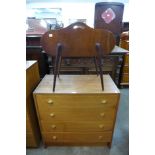 A teak chest of drawers and a tambour top sewing table