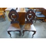 A pair of Victorian carved mahogany hall chairs