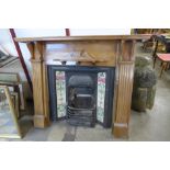 A Victorian style cast iron and tiled fire surround with pine chimneypiece