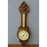 A carved walnut aneroid barometer