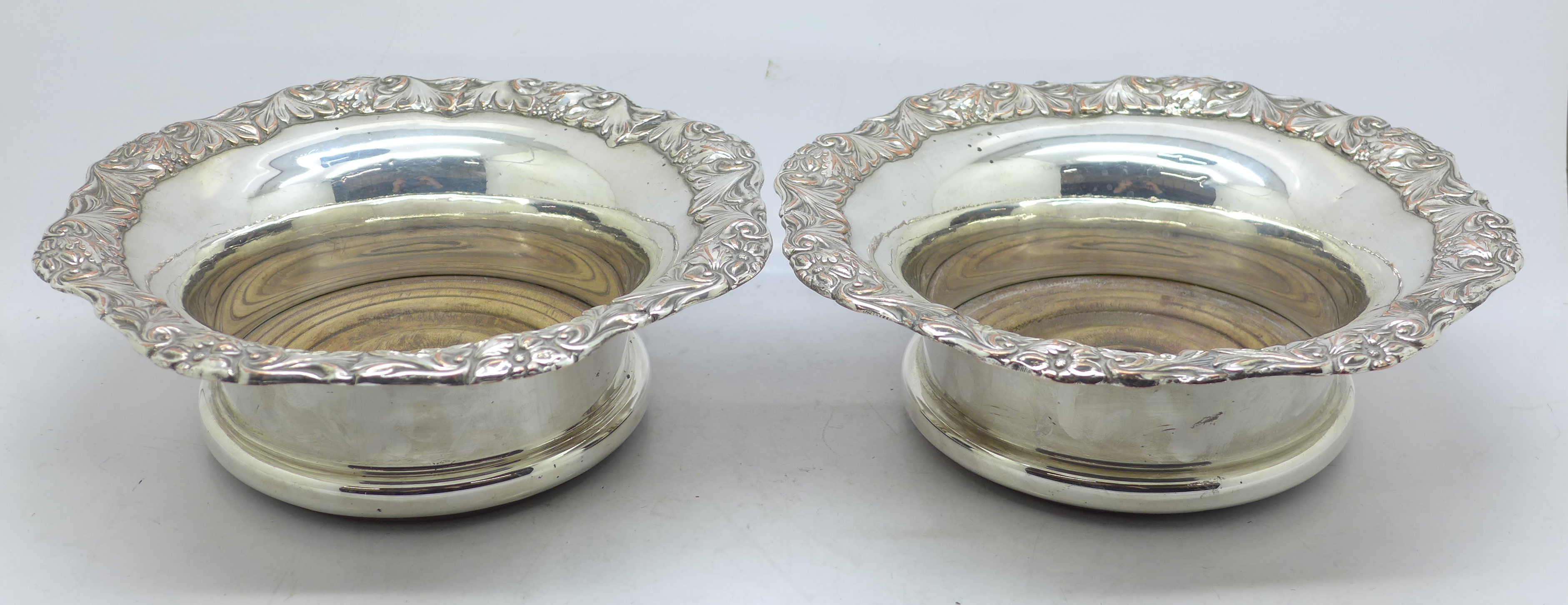 A pair of silver plated wine coasters