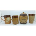 A Doulton Lambeth tobacco jar, two mugs and a beaker, chips on rim of tobacco jar