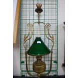 A brass ceiling light with green glass shade