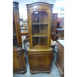 A walnut freestanding corner cabinet