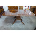 A Regency style inlaid mahogany extending pedestal table