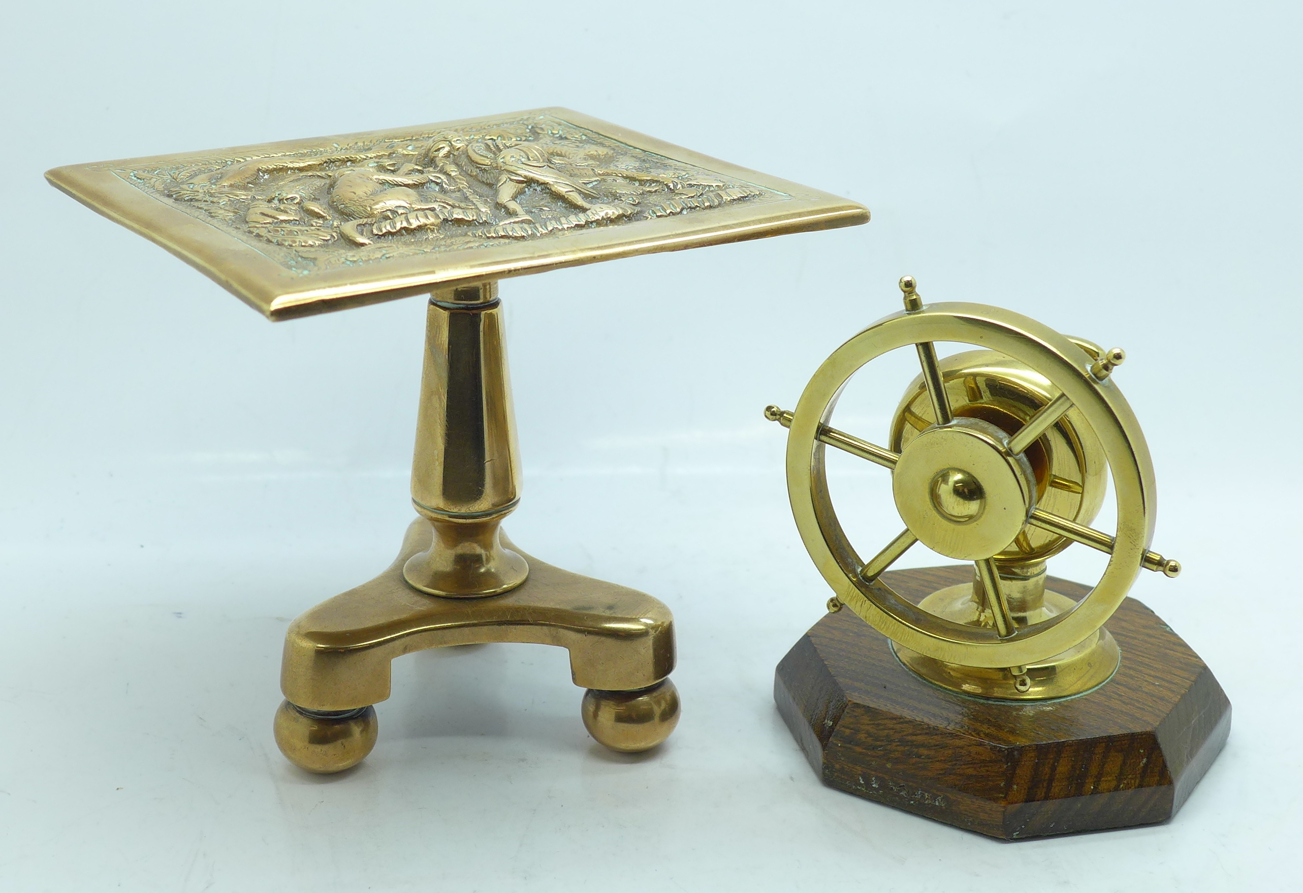 A miniature brass tilt-top table and a brass ship's wheel nut cracker