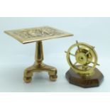 A miniature brass tilt-top table and a brass ship's wheel nut cracker