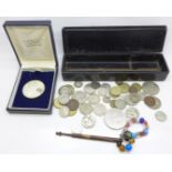 A Maria Theresia thaler and other coins and a lace bobbin with beads and a silver coin