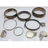 Four silver bangles, two other bangles and four silver lockets with chains