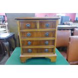 A yew wood bedside chest of drawers