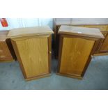 A pair of teak single door cabinets