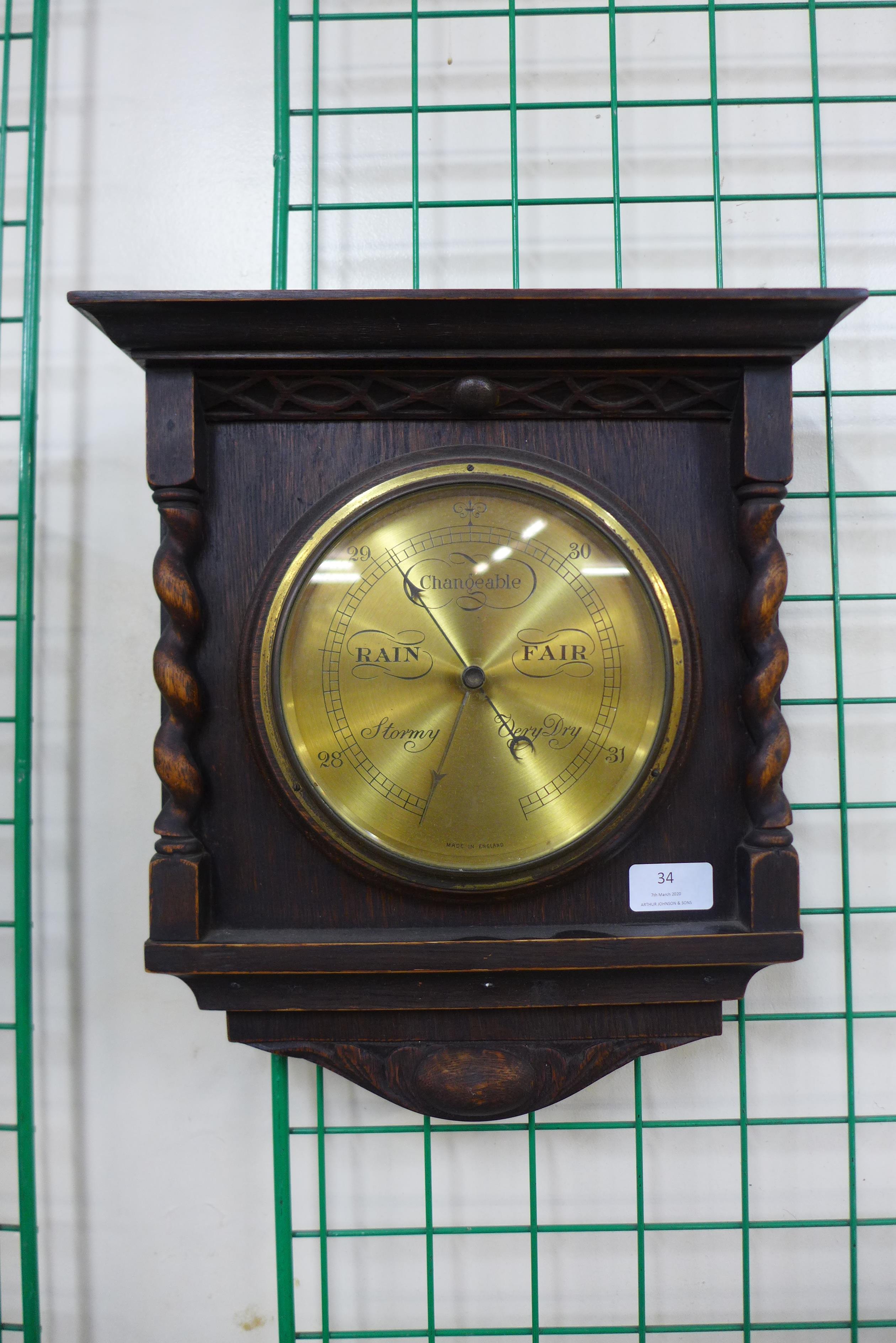 An early 20th Century carved oak barleytwist aneroid barometer