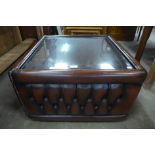 A brown leather and glass topped coffee table