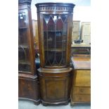 A walnut freestanding corner cabinet