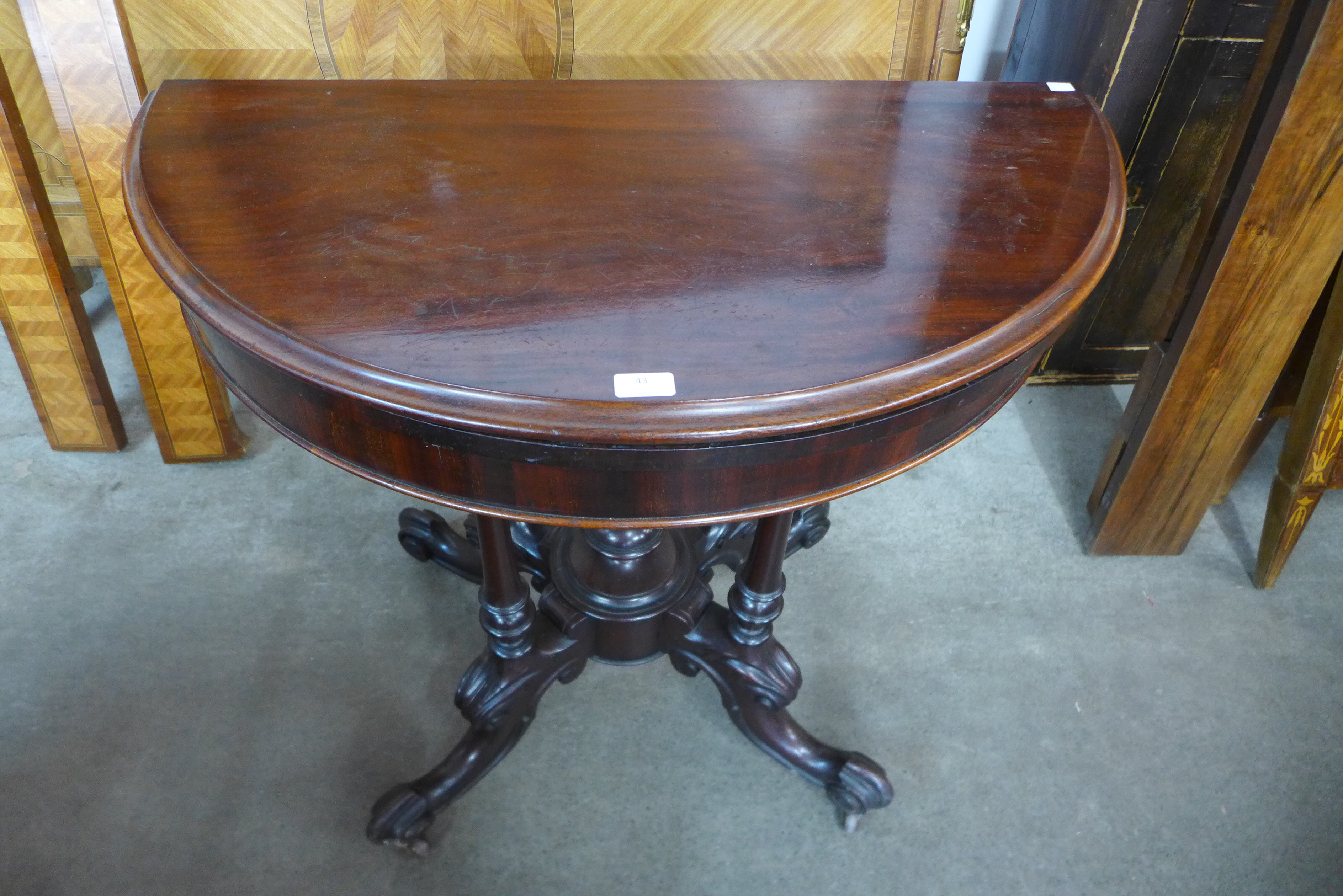 A Victorian carved mahogany demi line fold-over card table