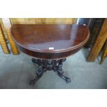A Victorian carved mahogany demi line fold-over card table