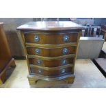 A yew wood serpentine bedside chest of drawers