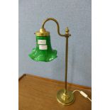 A brass desk lamp with green glass shade