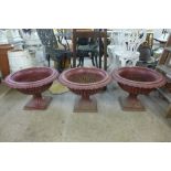 A set of three late Victorian painted cast iron campana shaped garden urns