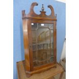 A mahogany wall hanging corner cabinet