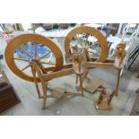 Two wooden spinning wheels and a bobbin stand