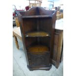 A carved oak freestanding corner cabinet