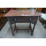 A 17th Century style oak single drawer side table