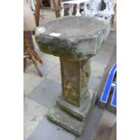 A reconstituted stone bird bath