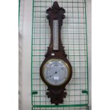 A carved oak aneroid barometer